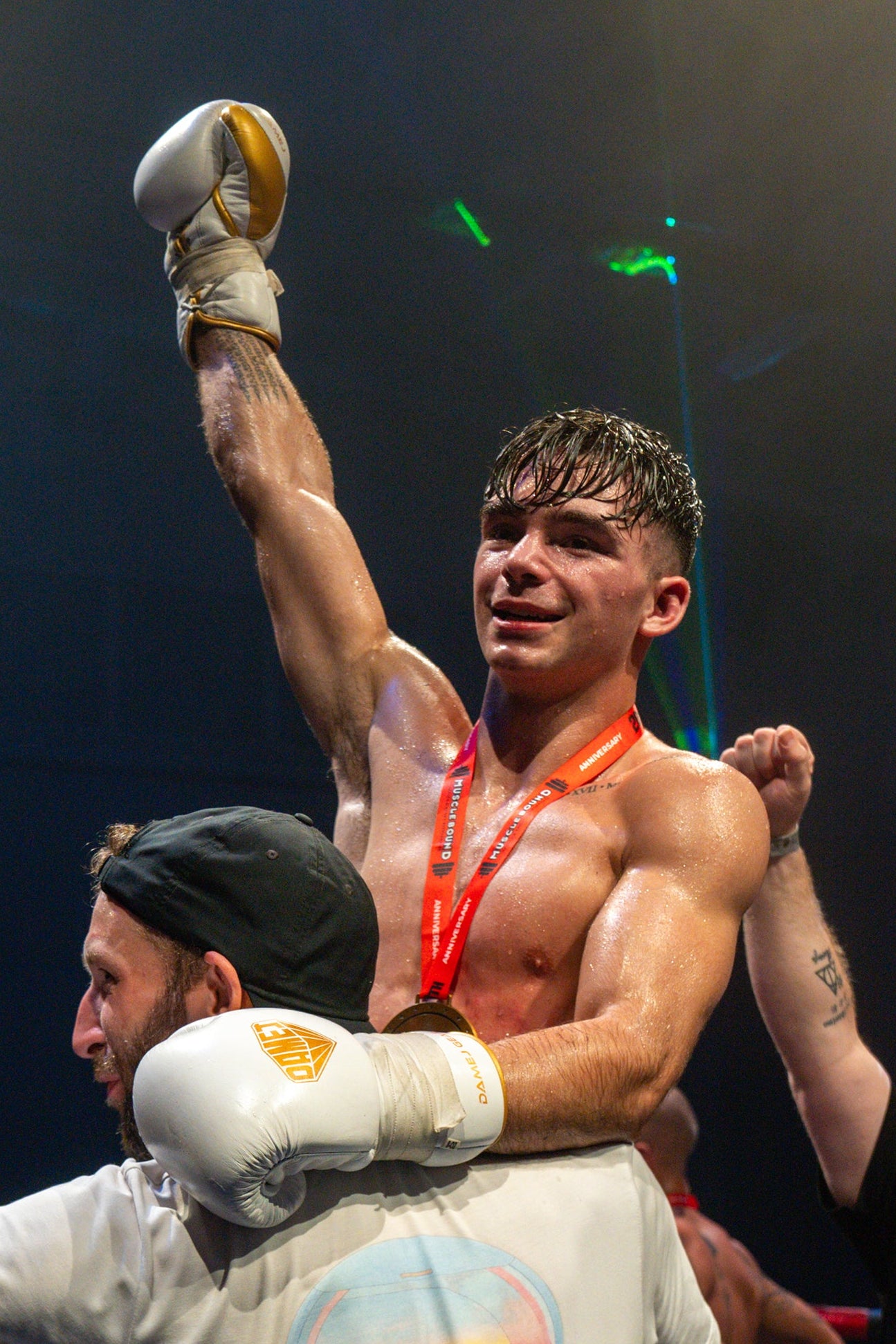 Rudy da silva celebrates a muay thai victory with supporters in a boxing ring.